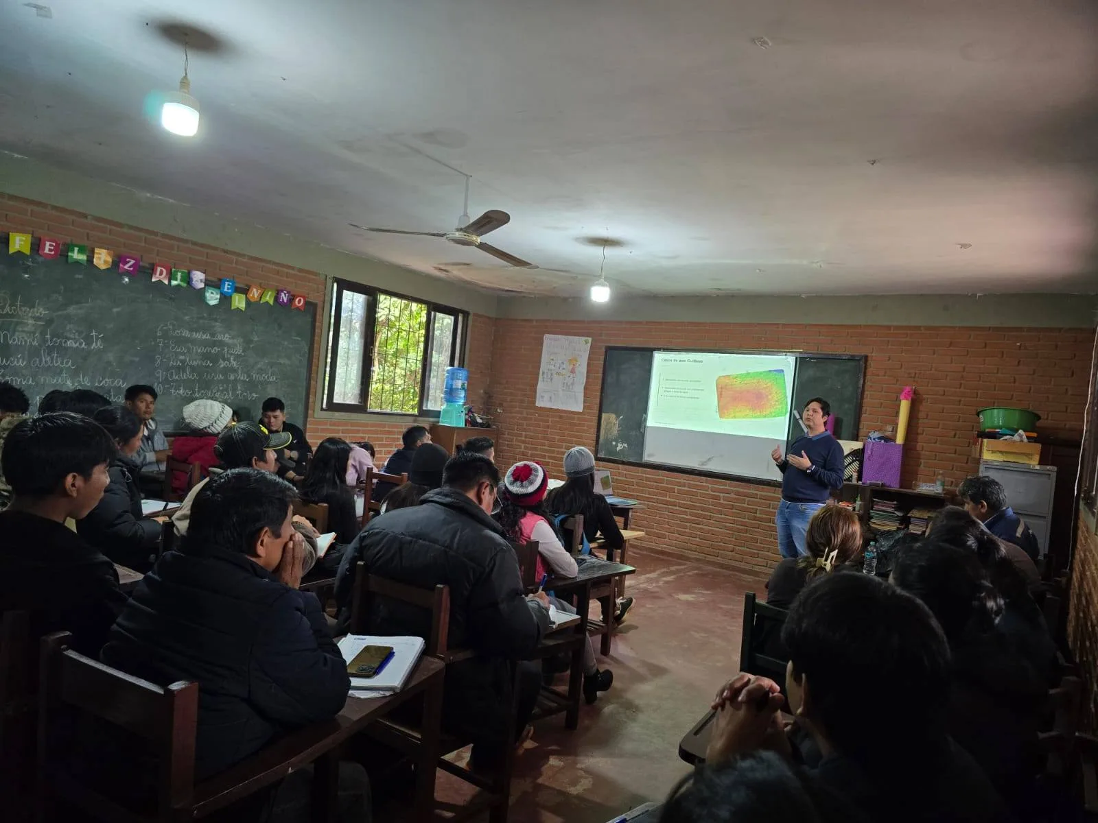 Facilitador presentando datos aéreos captados con drone a los participantes en el aula